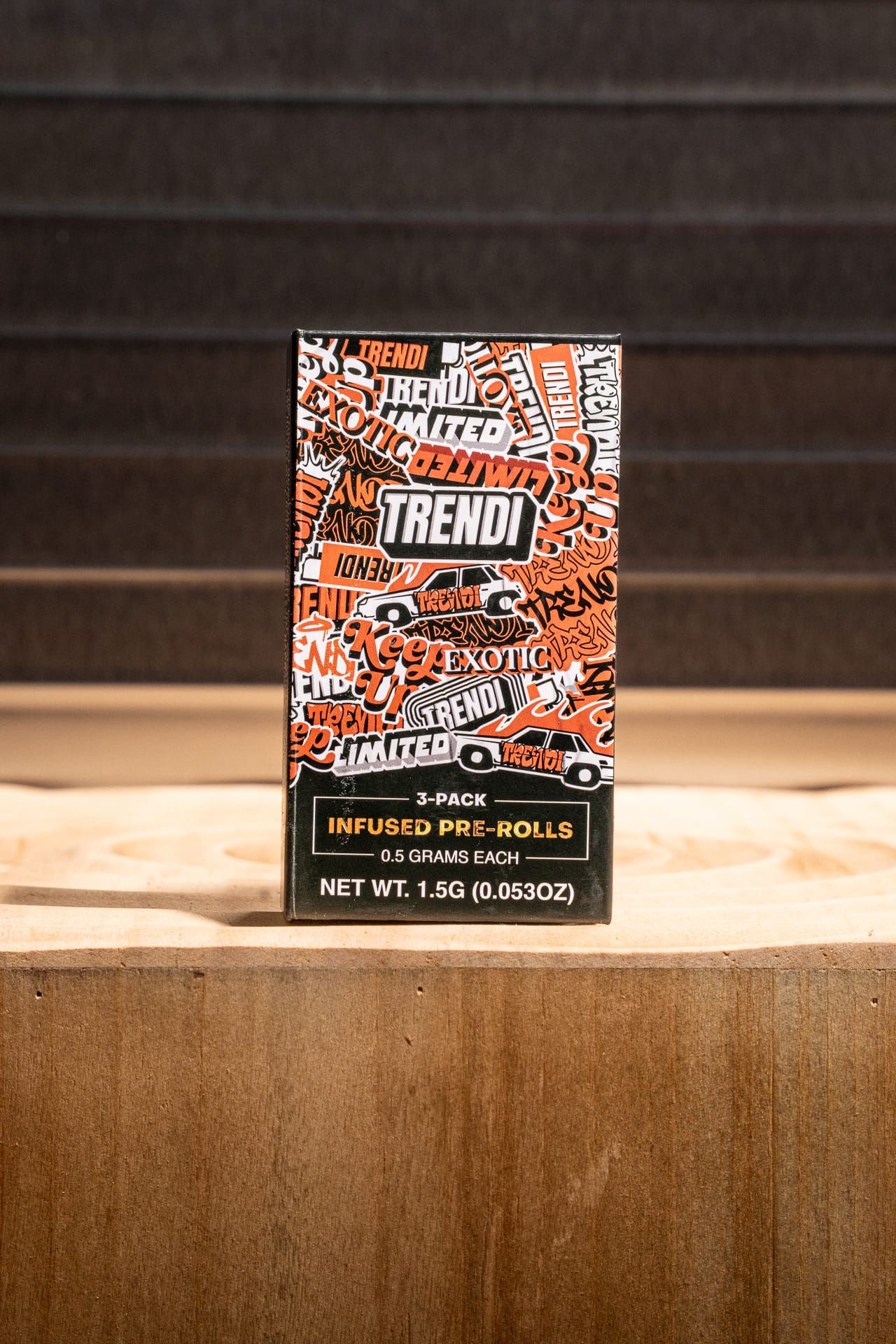 A TRENDI three-pack of infused pre-rolls, 1.5g total, standing on a wooden block